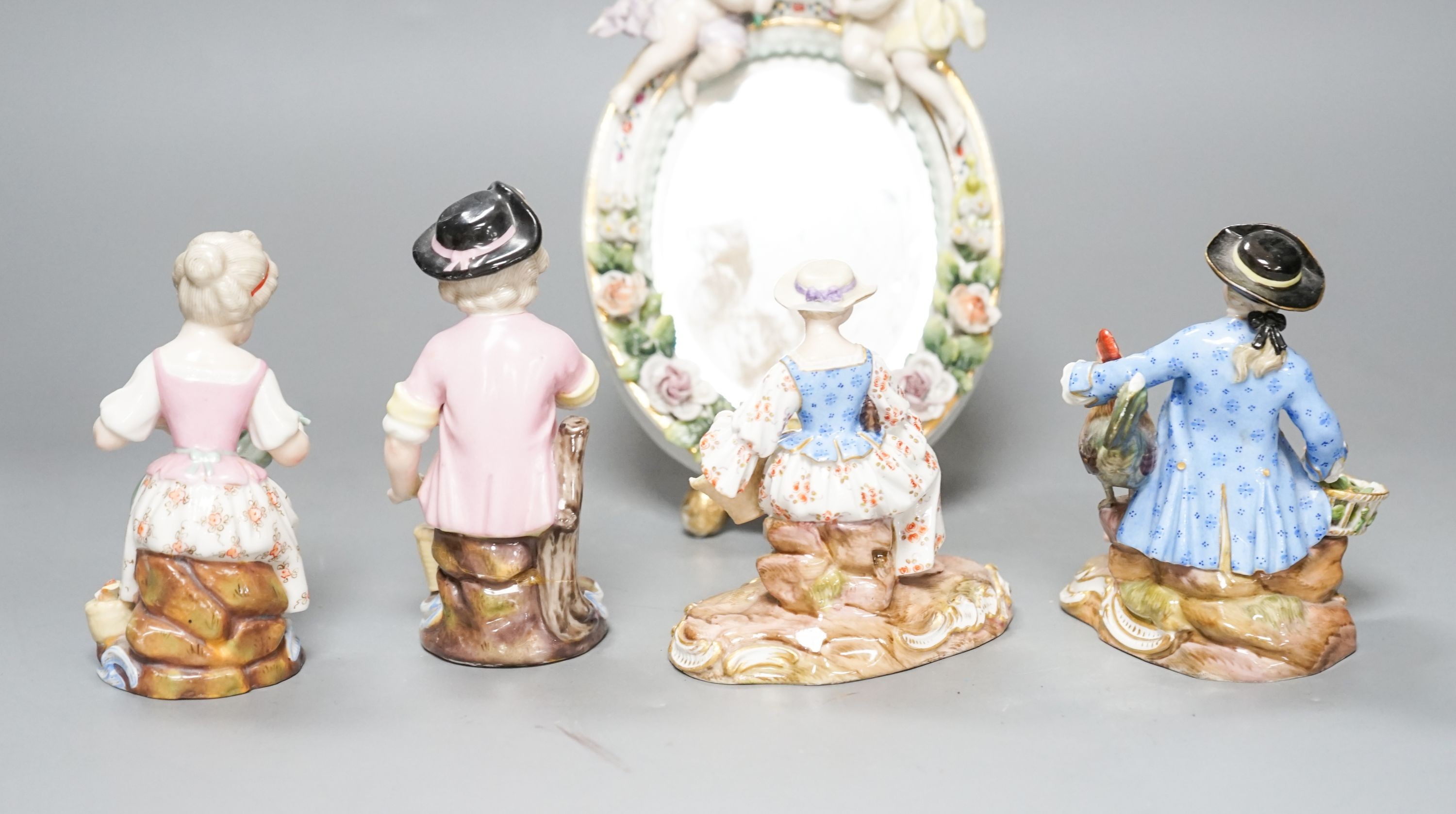 A pair of Meissen groups holding chickens, 10.5cm, a pair of Sitzendorph figures and a Sitzendorf mirror 18cm